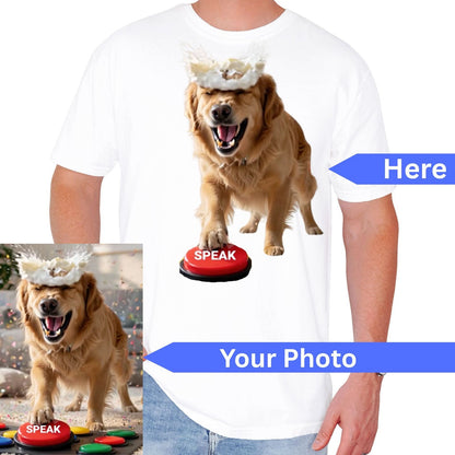White short-sleeve T-shirt shown on a cropped male model torso, featuring a printed graphic of a golden retriever standing on a red button labeled 'SPEAK' with a white feather-like headpiece. Blue arrows and text read 'Here' and 'Your Photo,' plus a small inset photo of the dog wearing the headpiece.